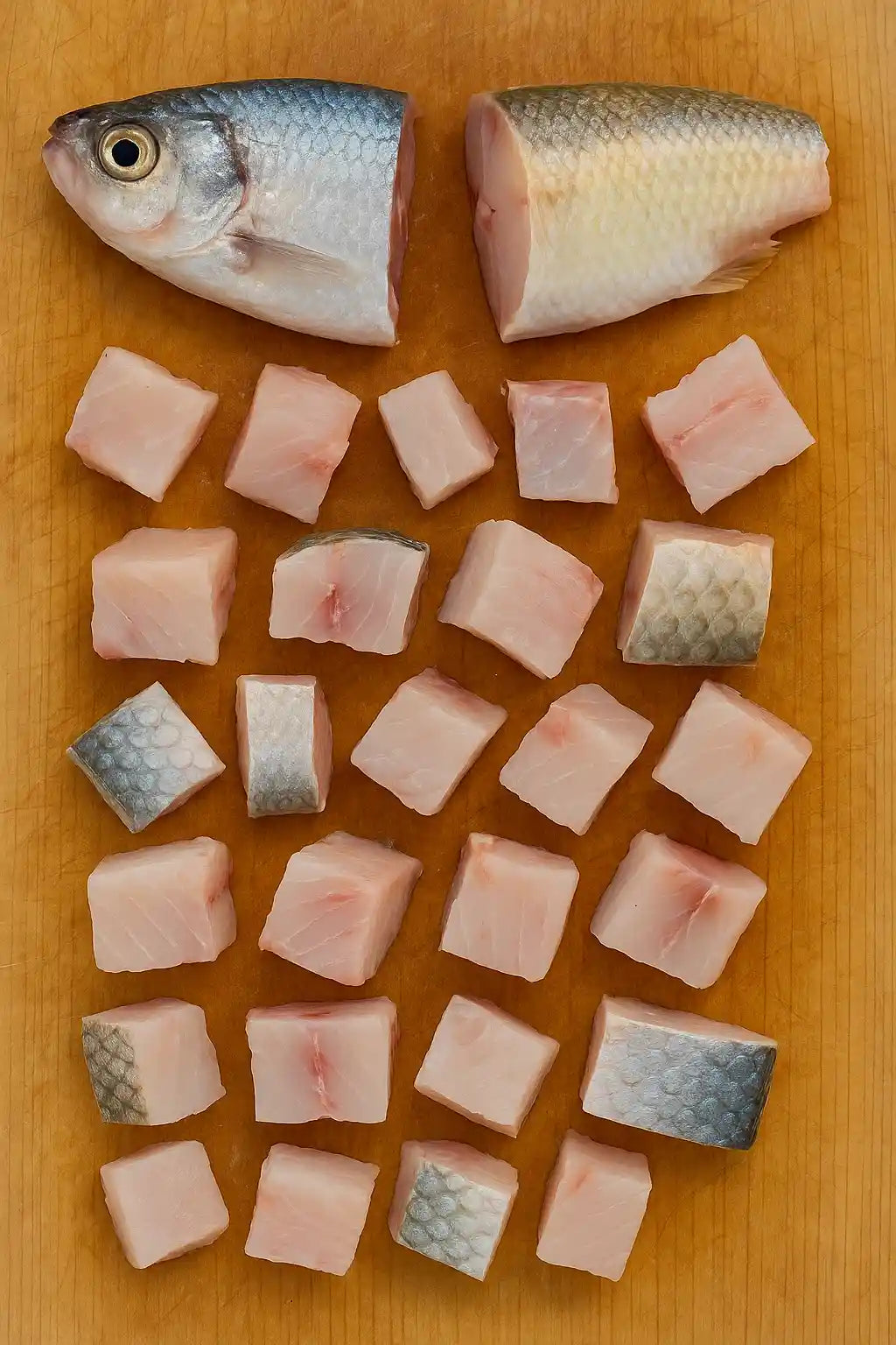 Fresh cut shad and mullet prepared as blue catfish bait on a cutting board.